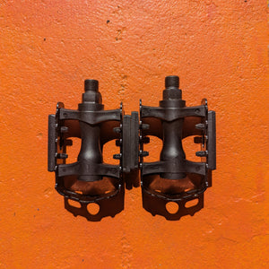 A pair of metal bicycle pedals in Style 5 design, featuring a sleek, durable construction with textured surfaces for improved grip.