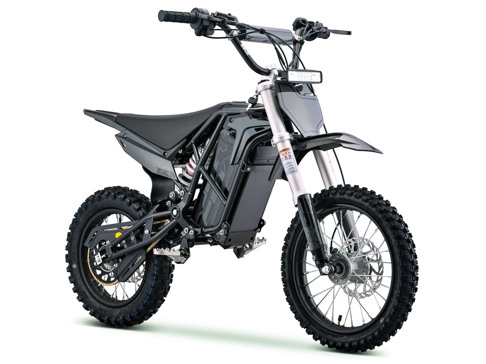 Side view of the eMOTO Stomp Ebox V3 72 RS electric dirt bike in a studio setting, showcasing its frame, wheels, and suspension components.