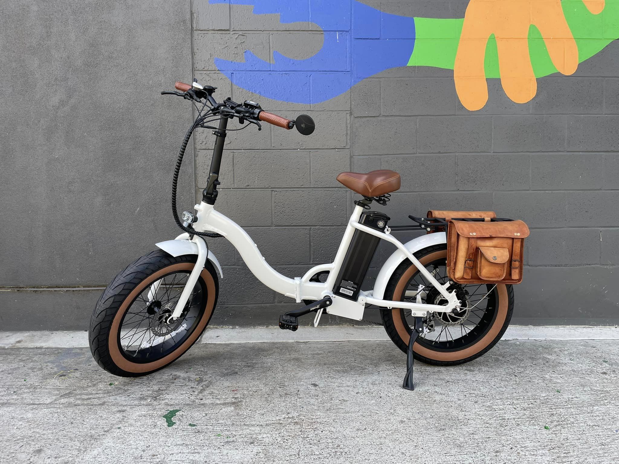White custom folding electric bike with step-thru frame, 20-inch fat tires, foldable design, product image against a white background.