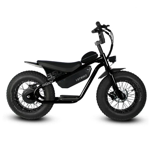 A black eMOTO eBike Strike Big Boy electric bicycle parked outdoors on a paved surface, showcasing its sturdy frame, thick tires, and battery pack.