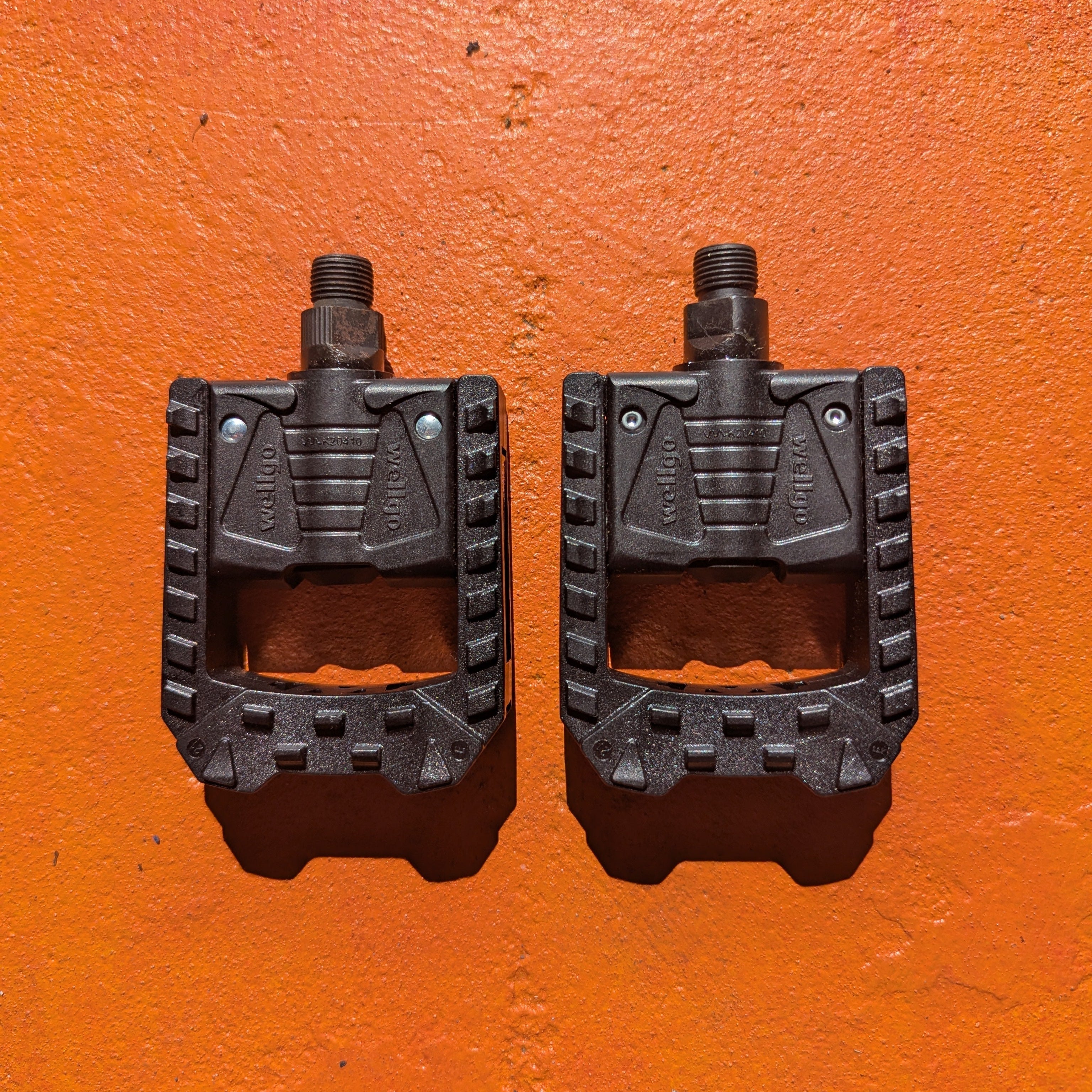 Black nylon folding style bicycle pedals, shown in a pair, designed for easy storage and transport.