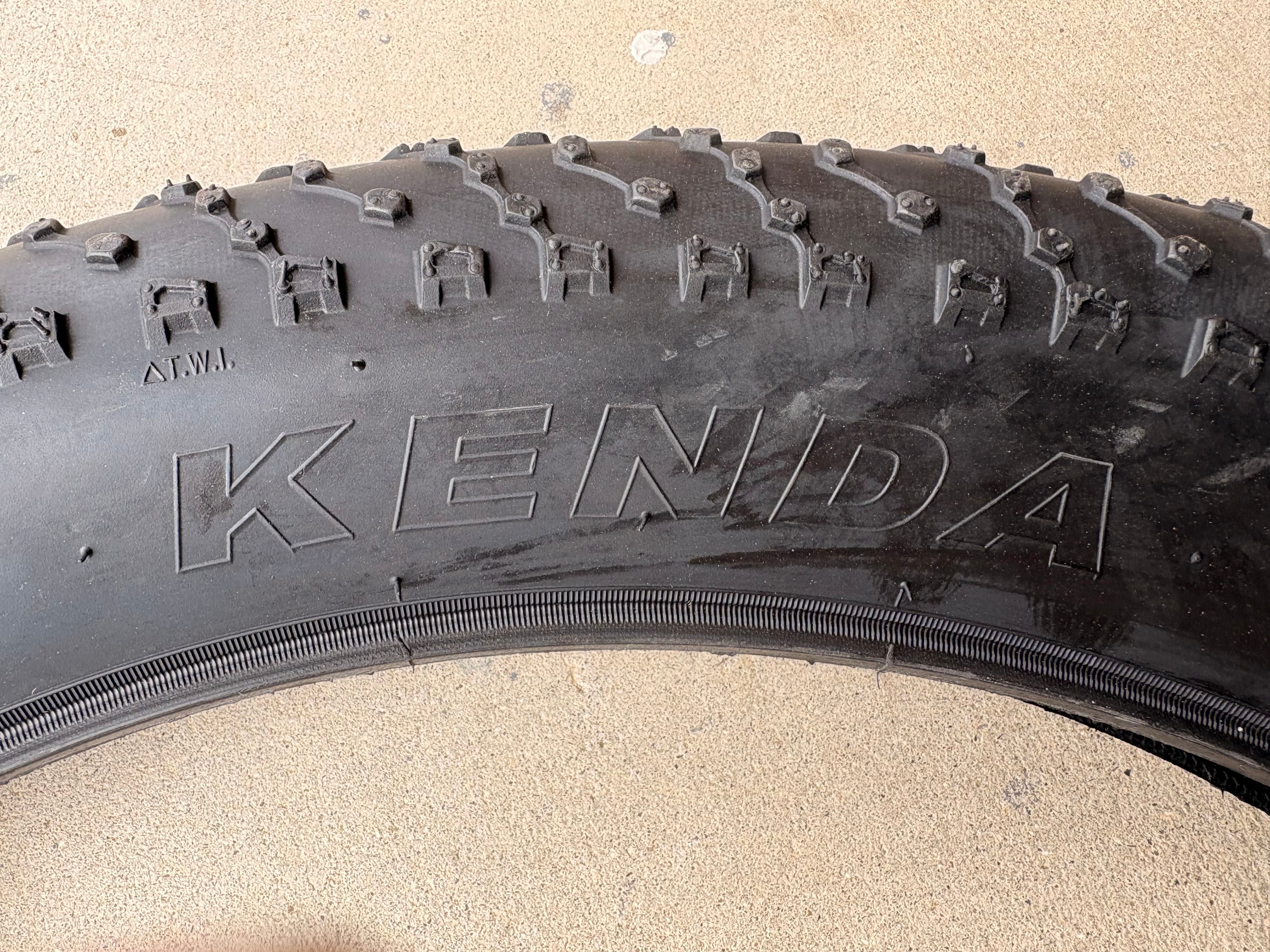 A black eBike with 26x4 inch Kenda Juggernaut fat tires, shown in a side profile against a white background.
