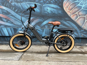 A black custom folding electric bike with a 750-watt motor, shown in a partially folded position against a white background.