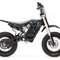 Stomp Ebox Megalith Graphics Kit displayed on a dirt bike, featuring bold geometric patterns in black, white, and neon yellow with the Stomp logo.