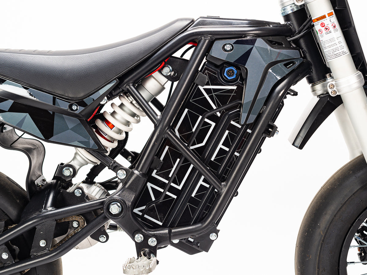 Stomp Ebox Megalith Graphics Kit displayed on a dirt bike, showcasing bold geometric patterns in black, white, and neon yellow with the Stomp logo on the side panels.
