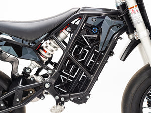 Stomp Ebox Megalith Graphics Kit displayed on a dirt bike, showcasing bold geometric patterns in black, white, and neon yellow with the Stomp logo on the side panels.