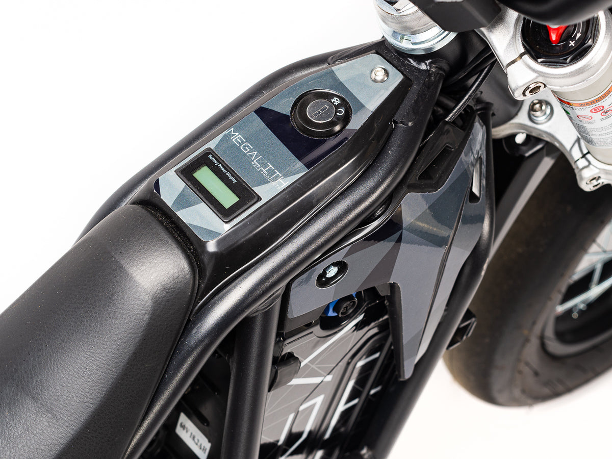 Stomp Ebox Megalith Graphics Kit displayed on a dirt bike, showcasing bold geometric patterns in black, white, and neon yellow with the Stomp logo on the side panels.