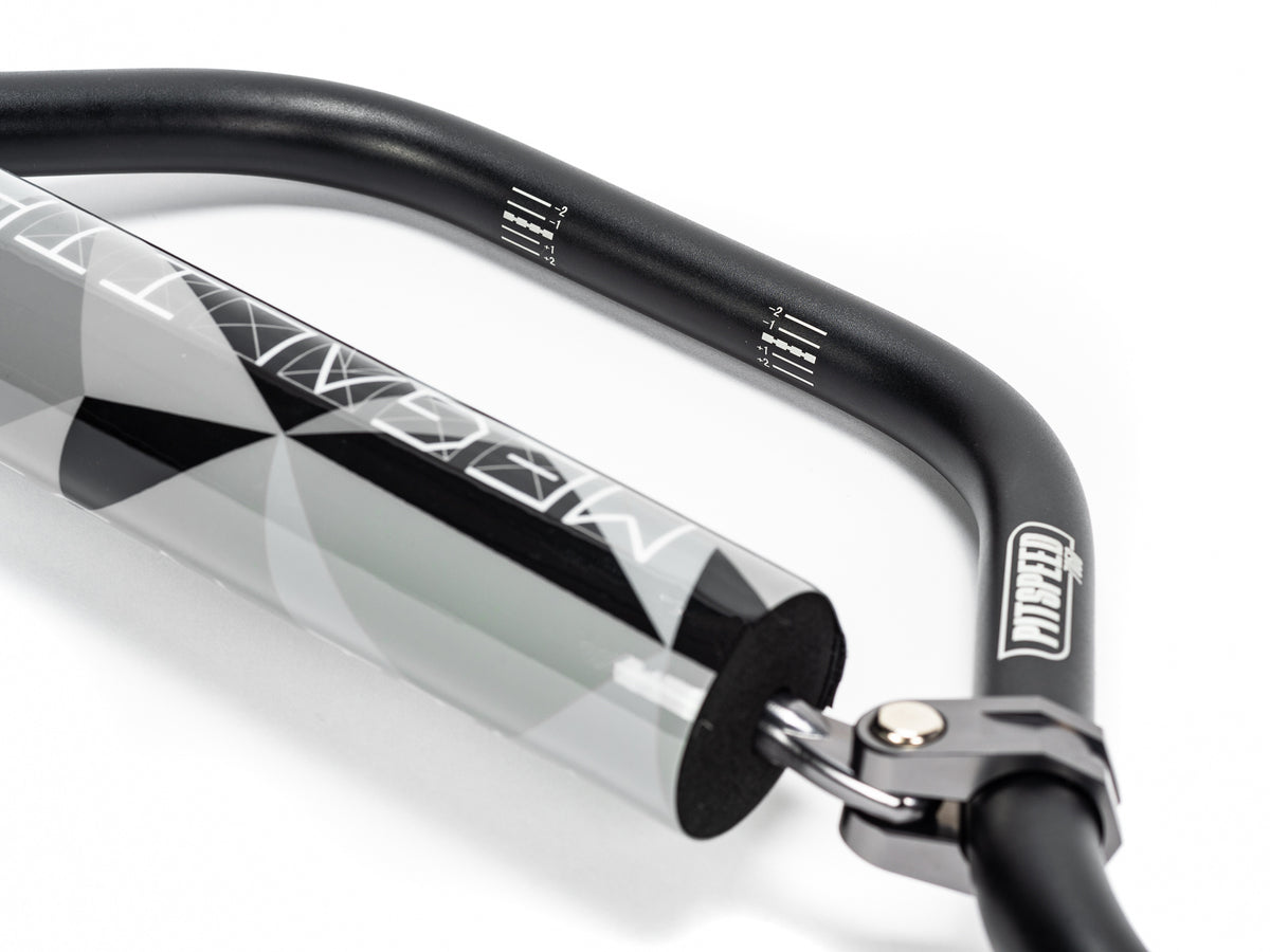 Stomp Ebox Megalith Pitspeed 7075 handlebar, close-up view showing black anodized finish, ergonomic bends, and laser-etched branding on the bar.