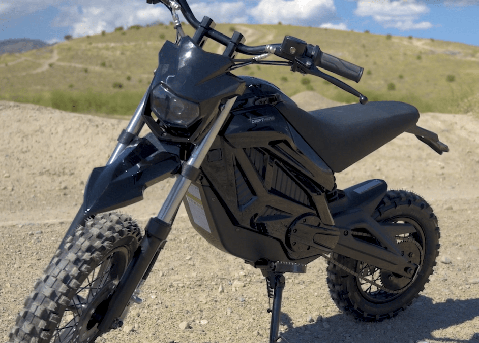 A black and red eMOTO eBike Drift Hero 800w dirt bike with rugged tires, sturdy frame, and electric motor, displayed on a white background.