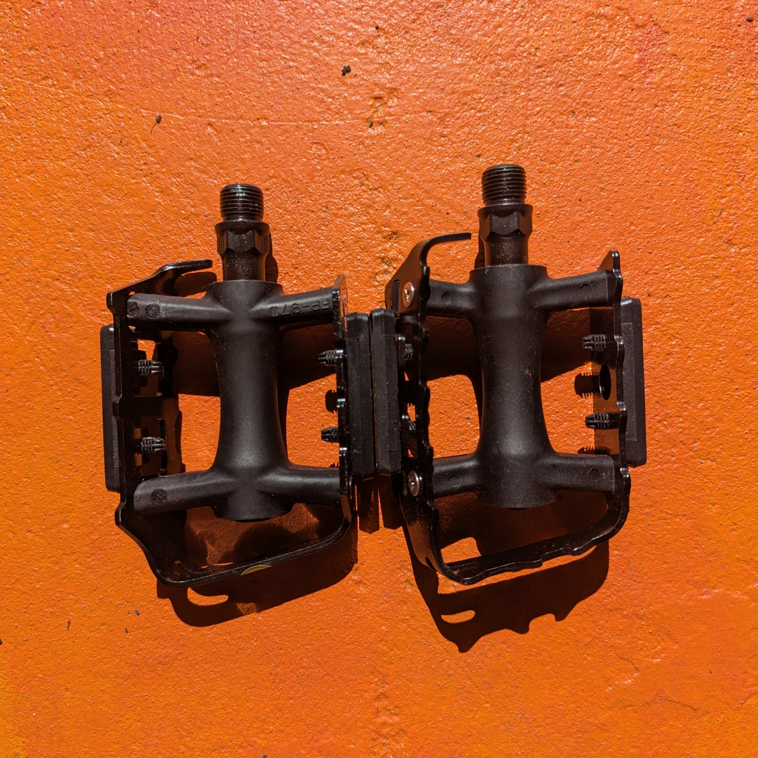 A pair of metal bicycle pedals in Style 7, featuring a sleek, modern design with a textured surface for grip and a silver finish.