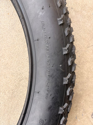 Electric fat tire bike featuring 26x4 inch Kenda Krusade tires, side view, black frame, outdoor background.