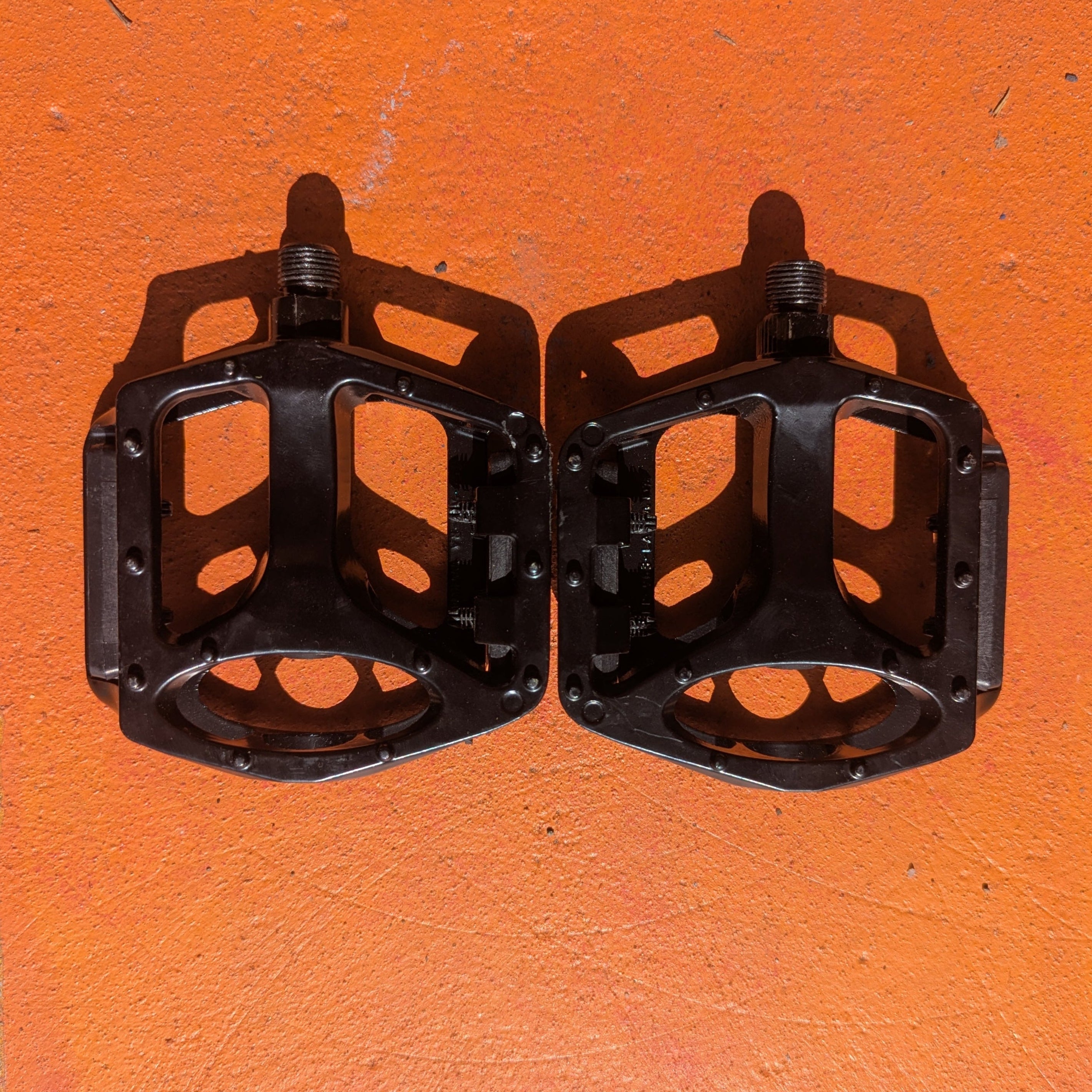 Close-up of a single metal eBike pedal in Style 1, featuring a textured surface and sturdy construction, photographed on a plain white background.